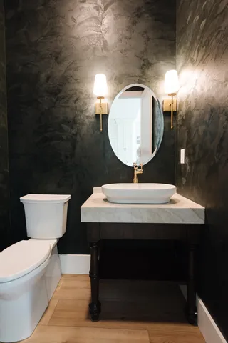 a bathroom with a toilet a sink and mirror