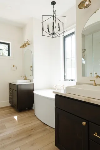 a bathroom with a sink double vanity granite tub shower and a mirror