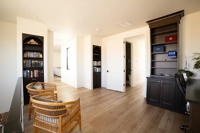 a living room with furniture a walk in closet and wooden floor