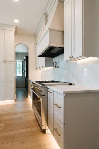 a kitchen with stainless steel appliances granite countertop a sink stove and cabinets