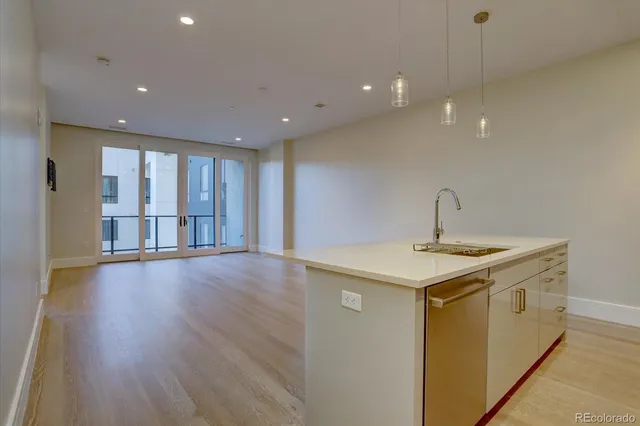 a kitchen with a sink and wooden floor