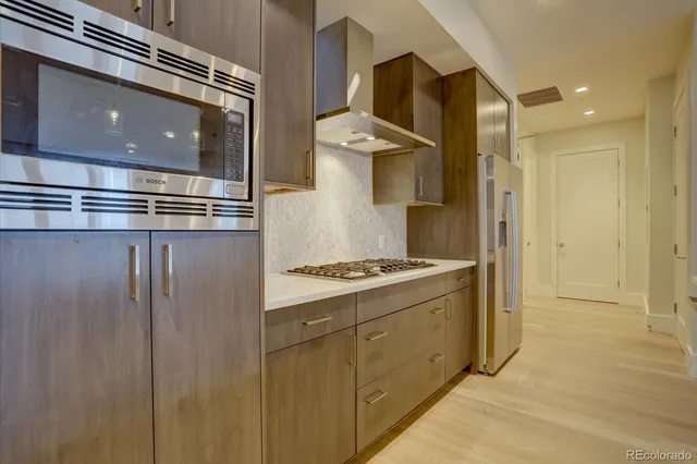 a kitchen with stainless steel appliances granite countertop a stove and a refrigerator