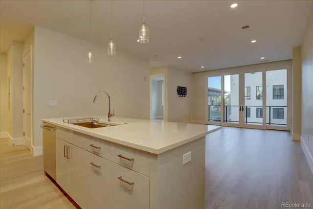 a view of a sink and dishwasher with wooden floor