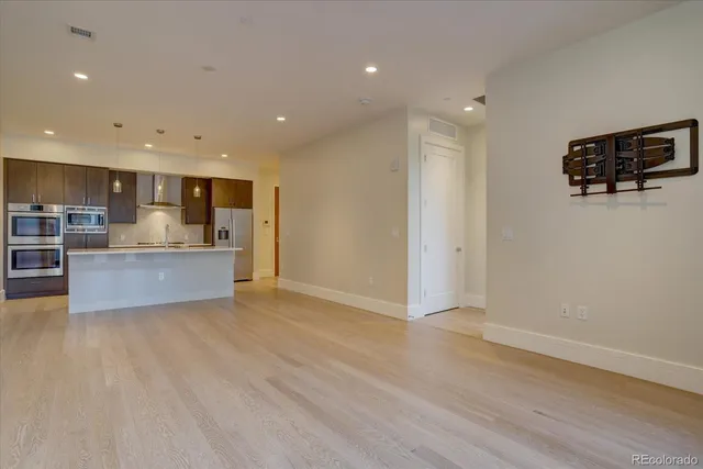 a view of kitchen with kitchen island granite countertop a stove top oven a sink and a refrigerator