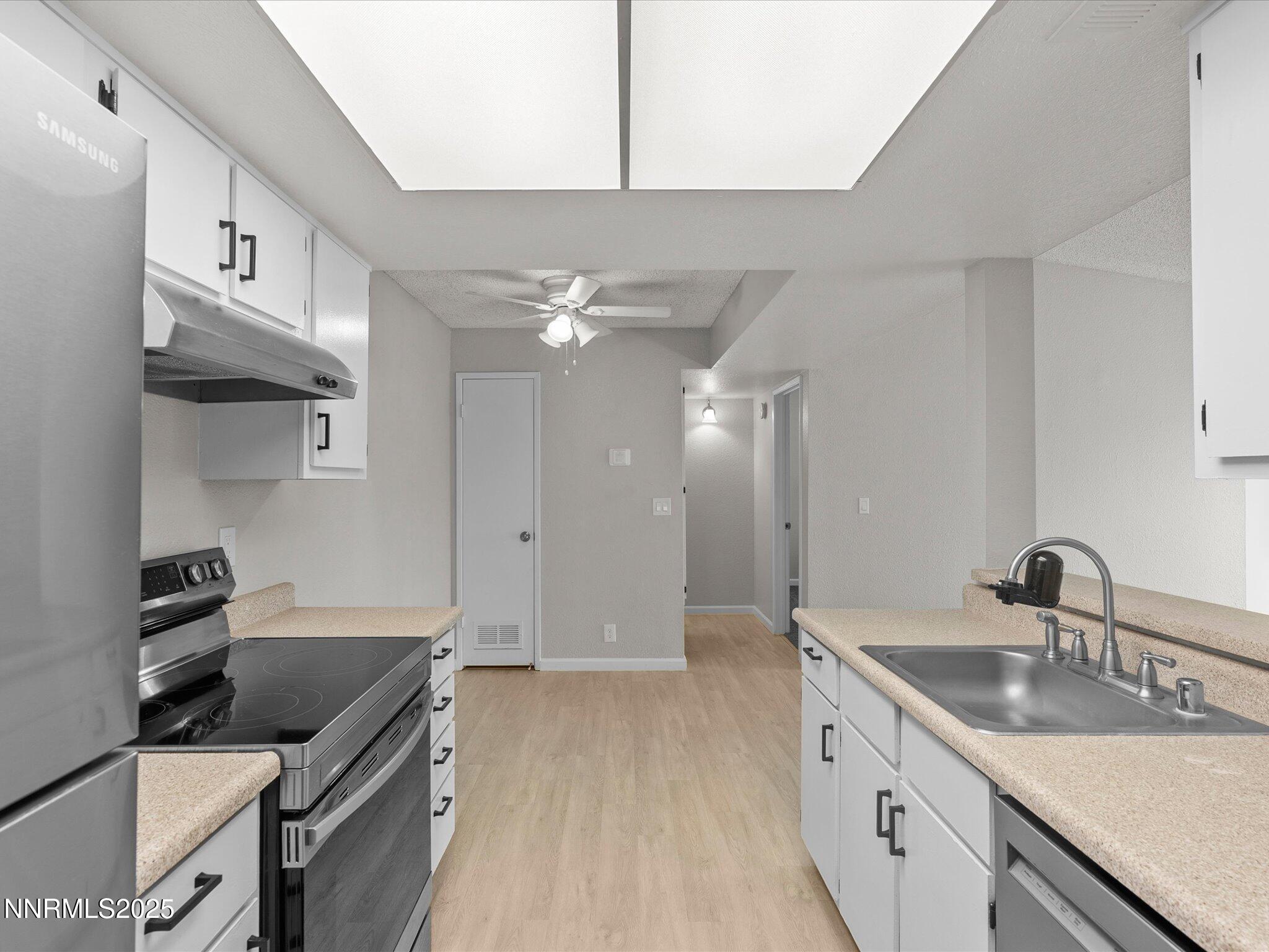 7680 Bluestone Drive, Unit 356 Reno, NV 89511 - Photo 11 of 23 a kitchen with a sink stove and cabinets