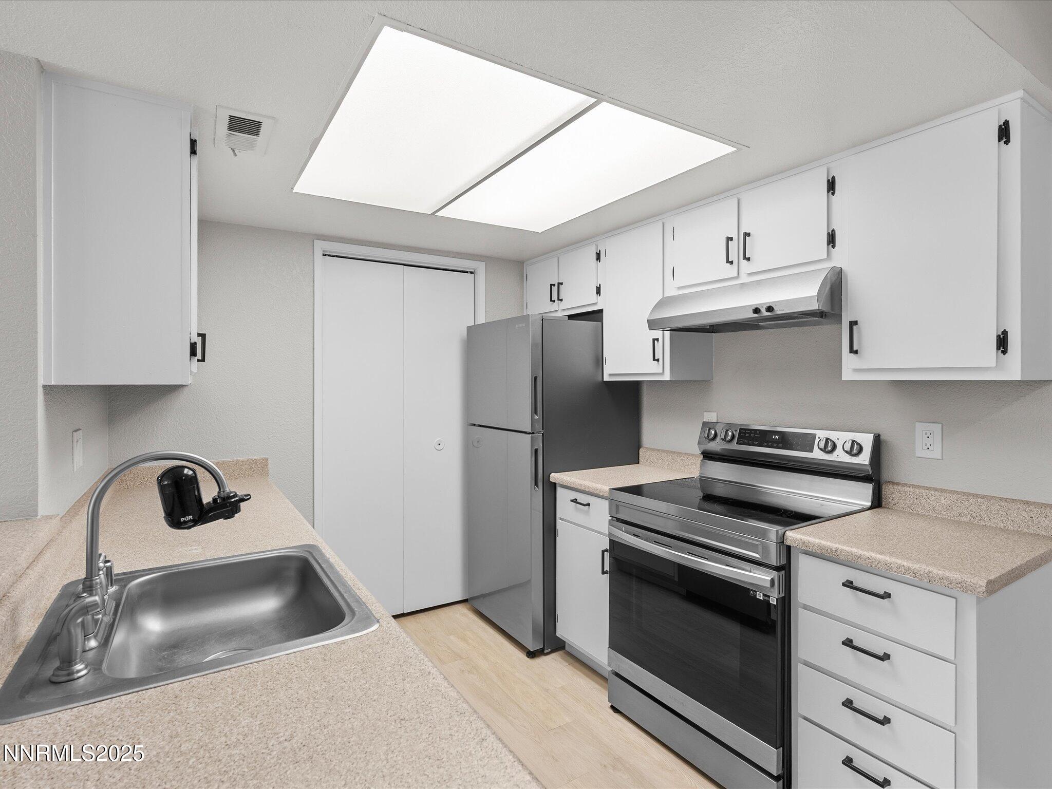 7680 Bluestone Drive, Unit 356 Reno, NV 89511 - Photo 10 of 23 a kitchen with granite countertop a sink stove and refrigerator