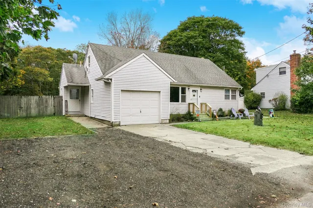 a view of a yard in front of a house with large tree