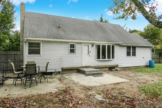 a backyard of a house with table and chairs