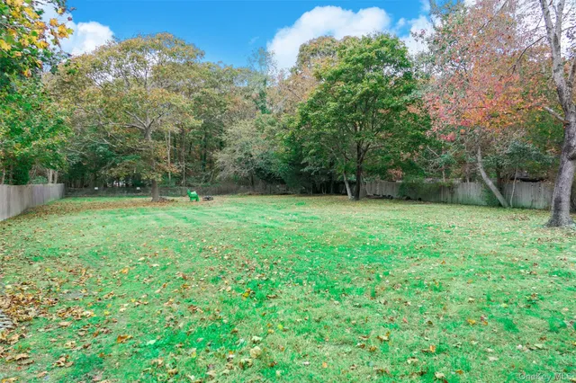 a view of a green field with trees in the background