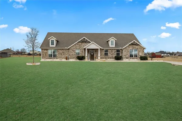 a front view of a house with a garden and yard