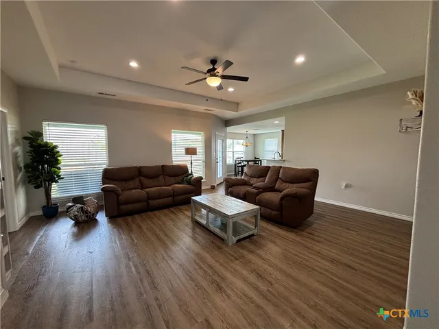 a living room with furniture and a wooden floor