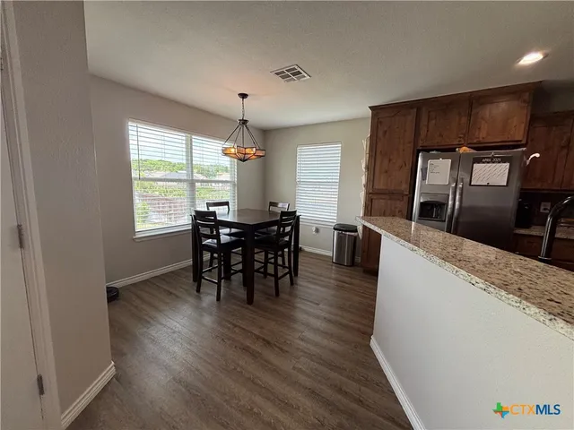 a kitchen with granite countertop wooden floors and stainless steel appliances