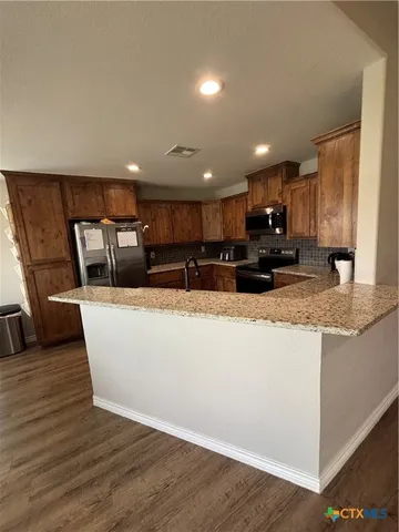a view of kitchen with granite countertop cabinets