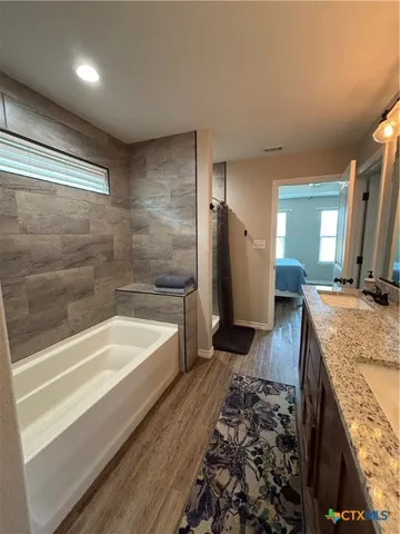 a spacious bathroom with a tub and a sink