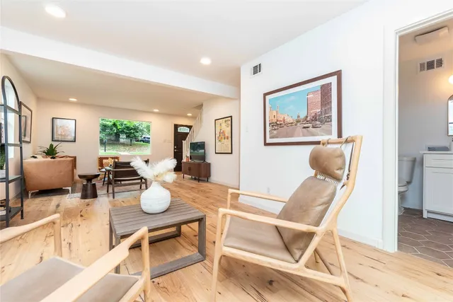 a view of a dining room with furniture a rug and wooden floor