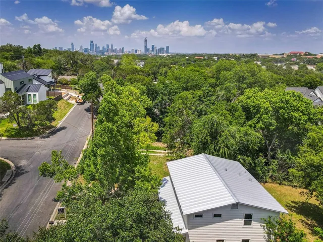 a view of a house with a big yard and large trees
