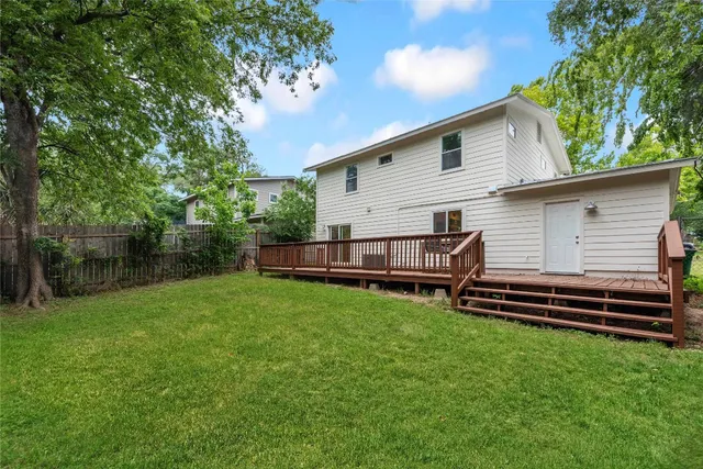 a aerial view of a house in front of a yard with plants and a small yard