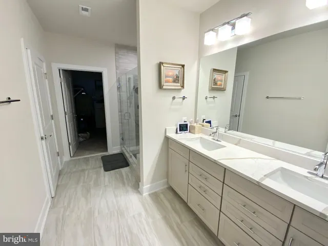 a spacious bathroom with a double vanity sink and a mirror