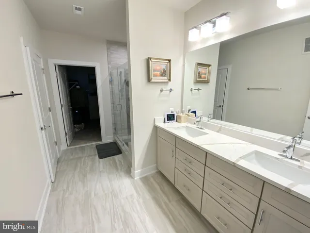 a spacious bathroom with a double vanity sink and a mirror