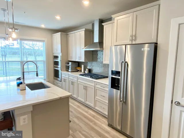 a kitchen with stainless steel appliances a refrigerator sink and cabinets