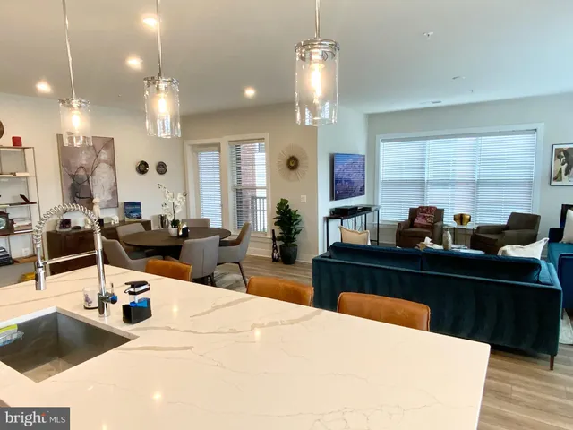 a kitchen with stainless steel appliances kitchen island granite countertop a sink white cabinets and chairs