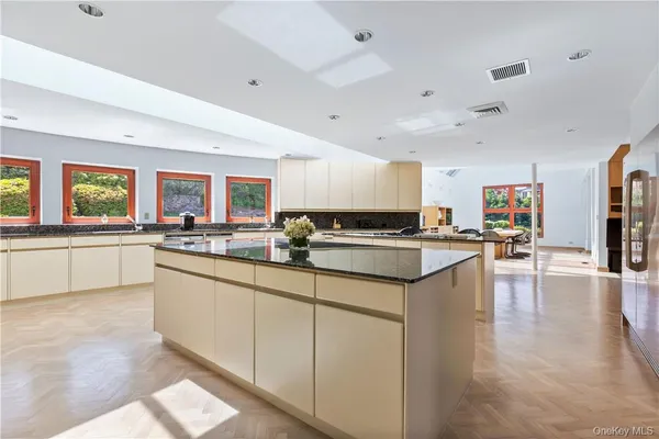a kitchen with stainless steel appliances a dining table chairs and a refrigerator