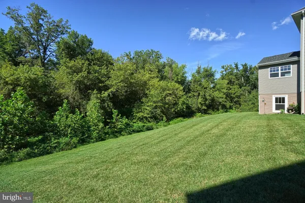 a view of a wooden deck and yard with green space