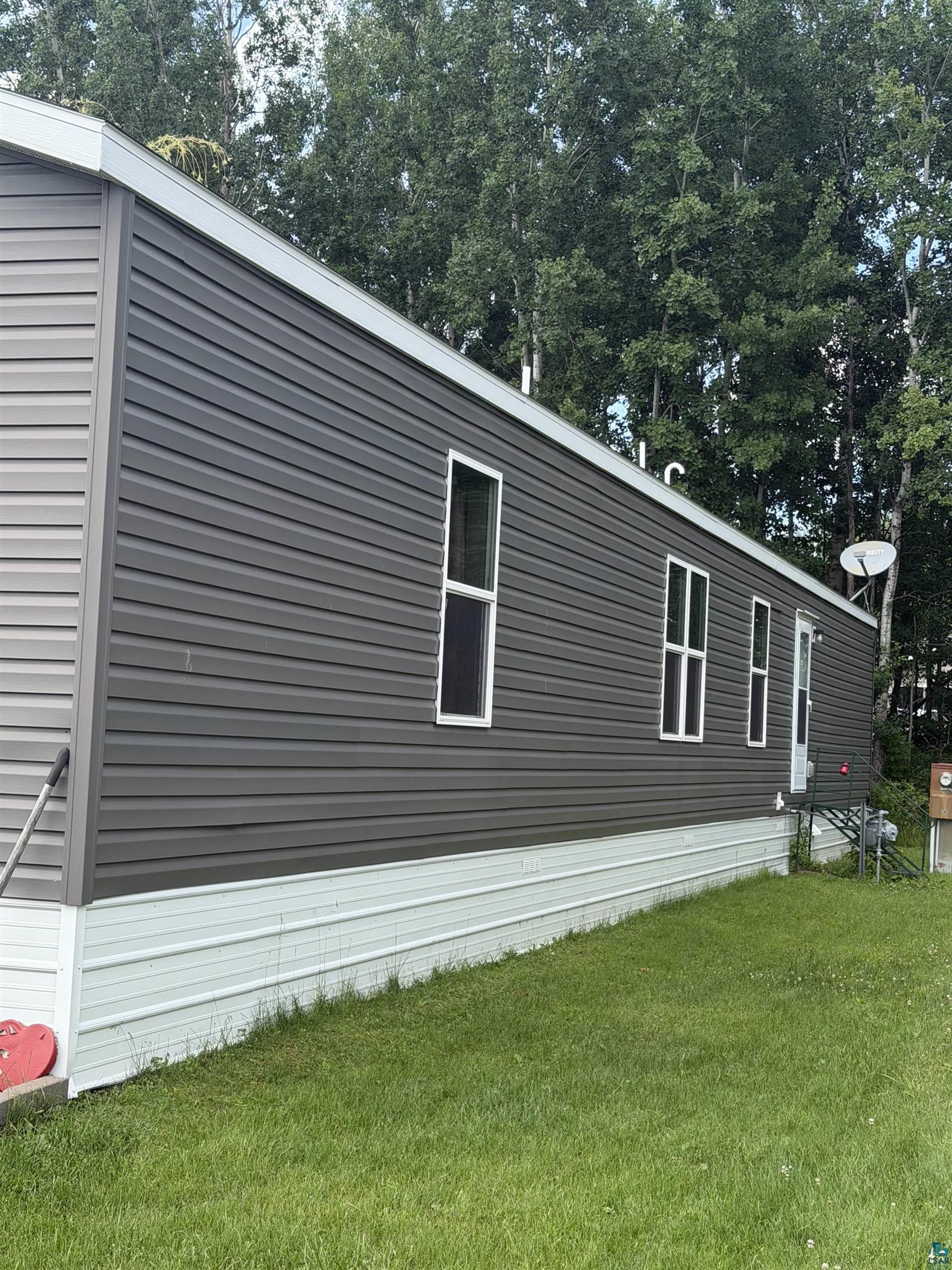 5051 Alpine Drive Hermantown, MN 55811 - Photo 4 of 24 Exterior featuring dark gray horizontal siding and multiple white-framed windows