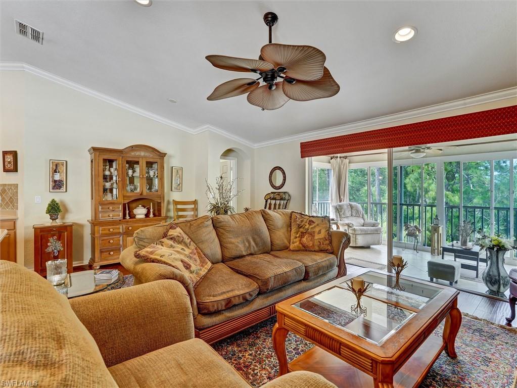 895 Eastham Way, Unit M202 Naples, FL 34104 - Photo 17 of 37 a living room with furniture ceiling fan and a large window