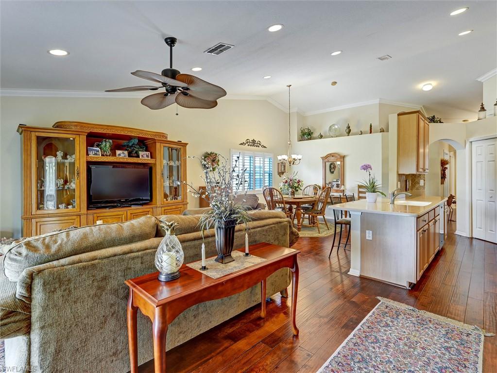 895 Eastham Way, Unit M202 Naples, FL 34104 - Photo 18 of 37 a living room with furniture kitchen view and a wooden floor