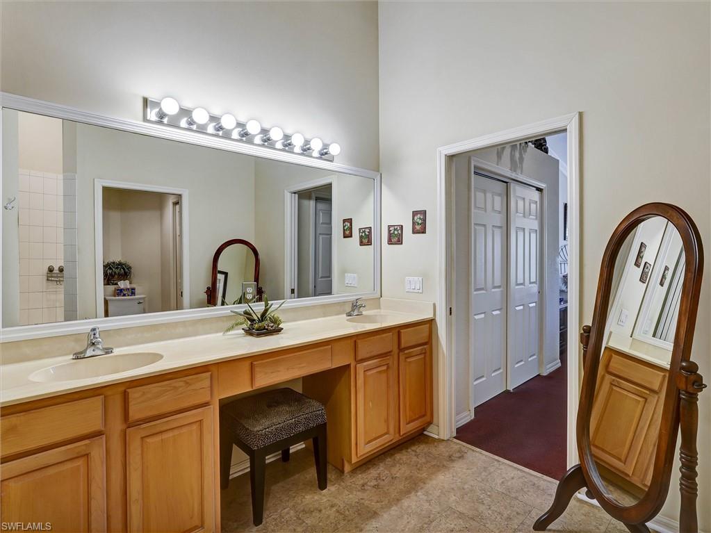 895 Eastham Way, Unit M202 Naples, FL 34104 - Photo 24 of 37 a bathroom with a sink a mirror and a shower