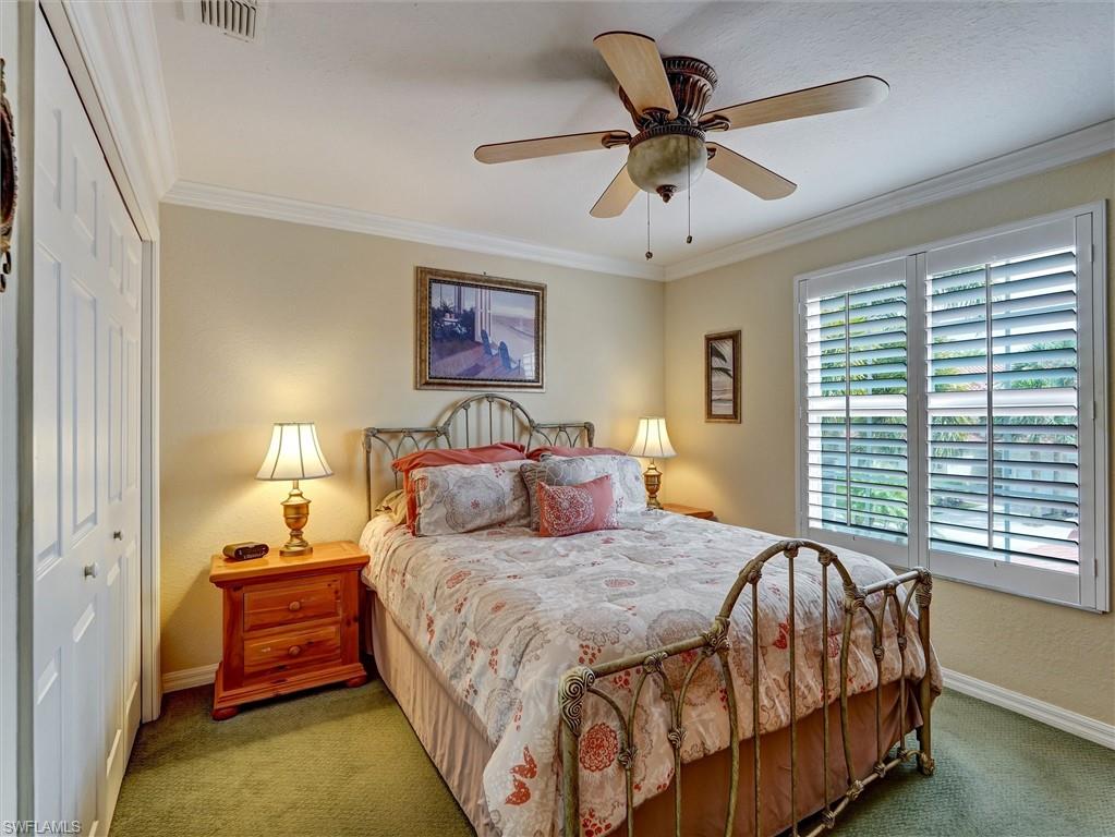 895 Eastham Way, Unit M202 Naples, FL 34104 - Photo 26 of 37 a bedroom with a bed and a large window