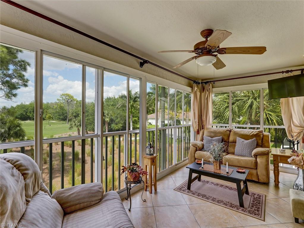 895 Eastham Way, Unit M202 Naples, FL 34104 - Photo 33 of 37 a living room with furniture and a floor to ceiling window