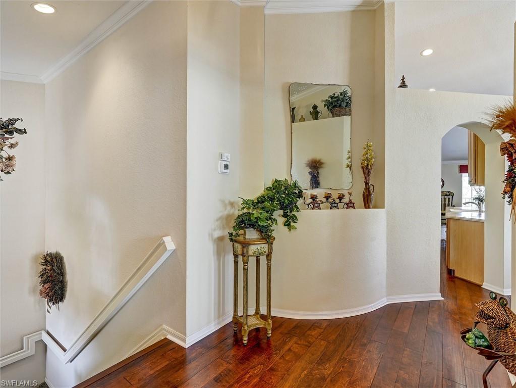 895 Eastham Way, Unit M202 Naples, FL 34104 - Photo 6 of 37 a view of a hallway with wooden floor and front door
