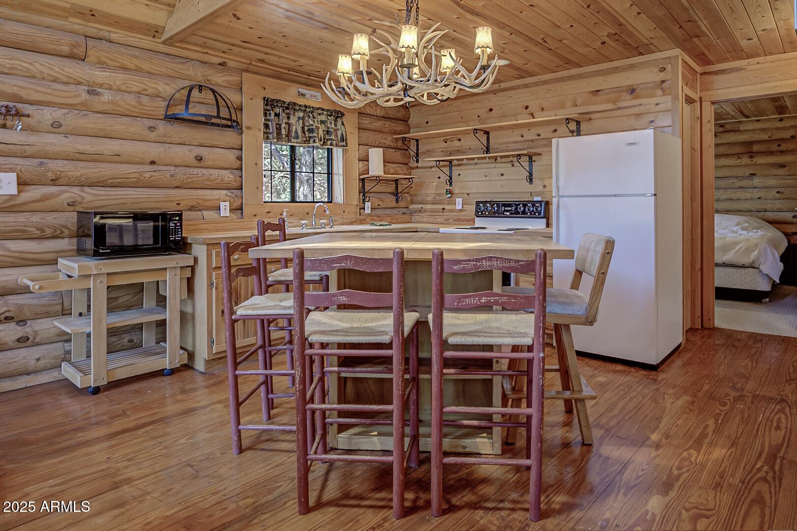 5945 Arroyo Way Pine, AZ 85544 - Photo 18 of 38 a view of a dining room with furniture wooden floor and chandelier