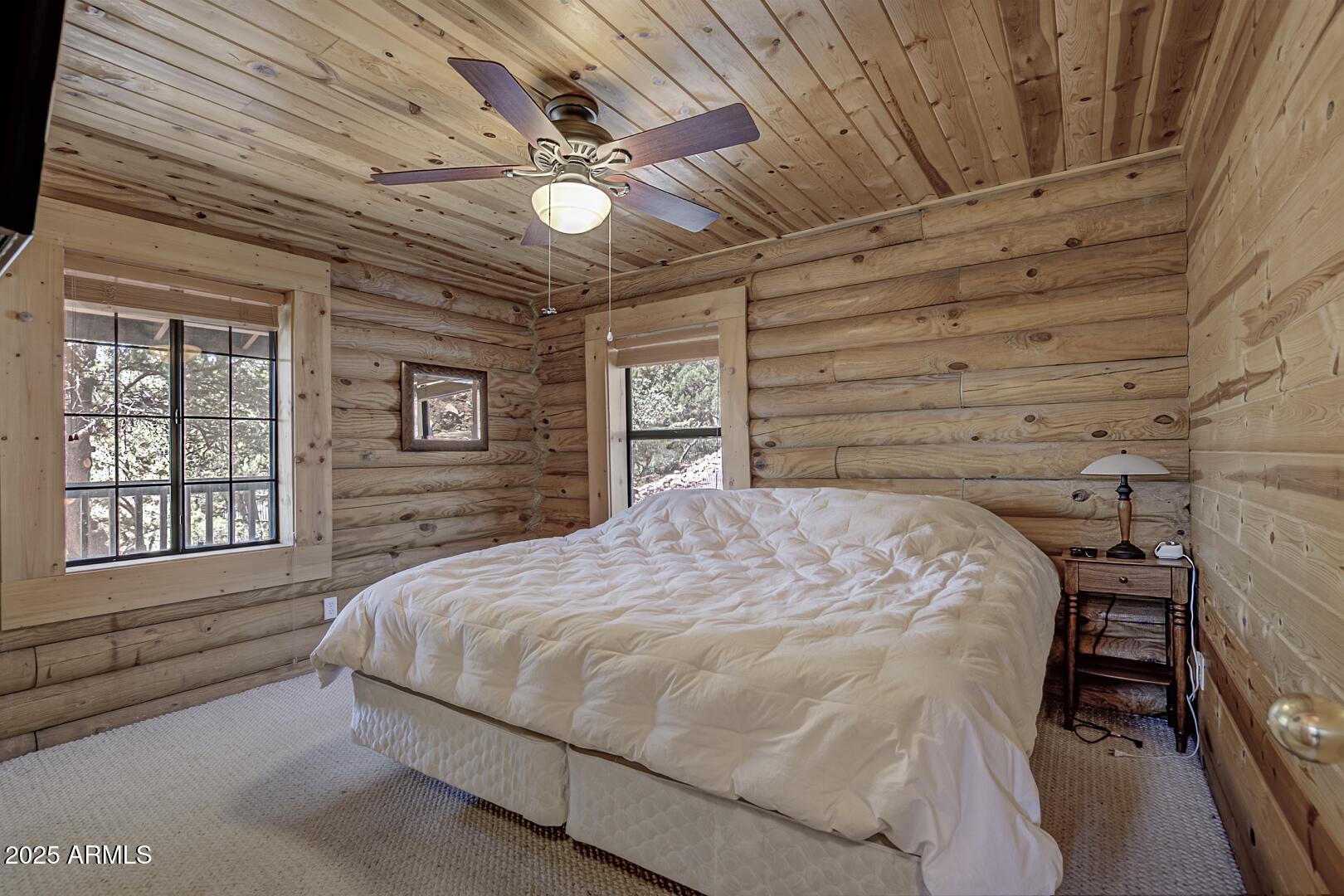 5945 Arroyo Way Pine, AZ 85544 - Photo 20 of 38 a bedroom with a bed next to a window with a flat tv screen