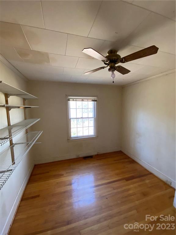 430 Russell Road Polkton, NC 28135 - Photo 16 of 18 an empty room with wooden floor fan and windows