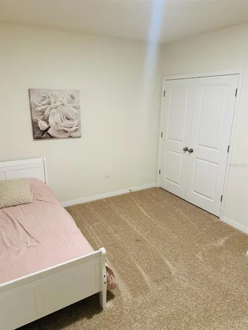 a bedroom with a bed and painting on the wall