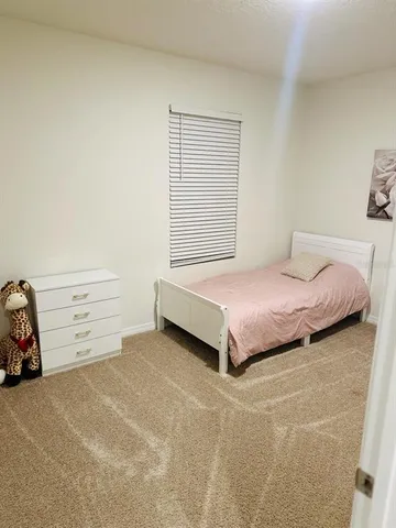 a bedroom with a bed and a car parked