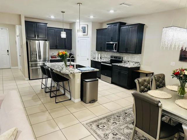a kitchen with stainless steel appliances kitchen island granite countertop a sink stove and refrigerator