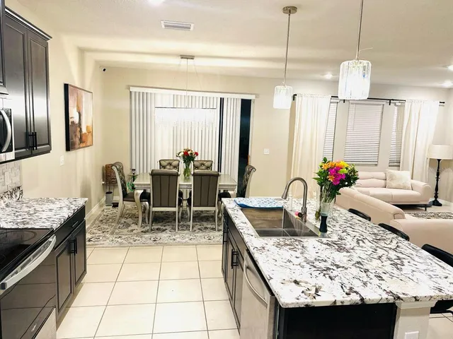 a kitchen with granite countertop a sink and a stove