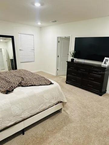 a bedroom with a bed and flat screen tv