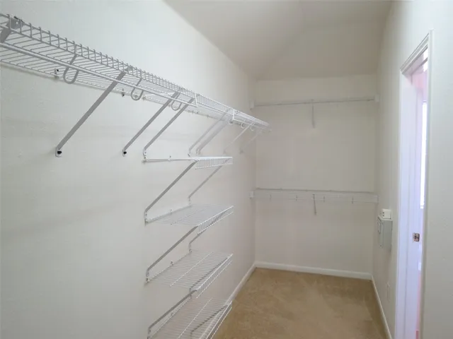a view of walk in closet with empty racks