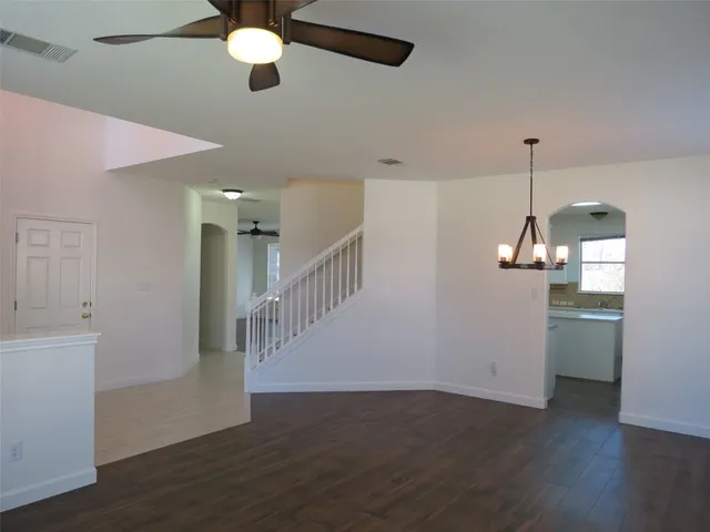 a view of a room with wooden floor and ceiling fan