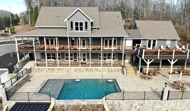 an aerial view of a house with swimming pool and sitting area
