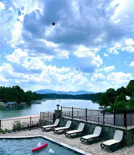 a view of a terrace with lawn chairs and iron fence