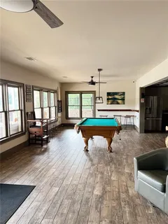 a living room with stainless steel appliances furniture a rug and a view of kitchen