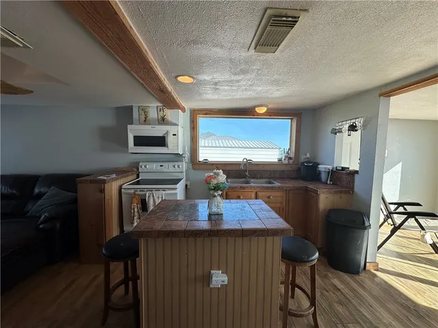 a kitchen with stainless steel appliances granite countertop a sink a stove top oven a counter space and cabinets