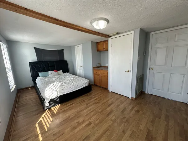 a bedroom with a bed and wooden floor