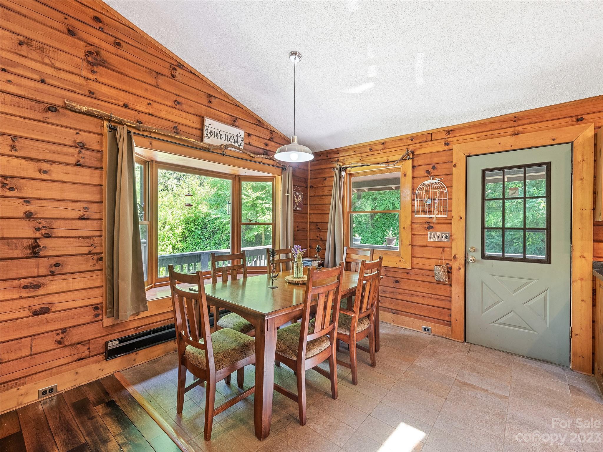 28 Honeybear Lane Clyde, NC 28721 - Photo 12 of 43 a view of a dining room with furniture large windows and wooden floor
